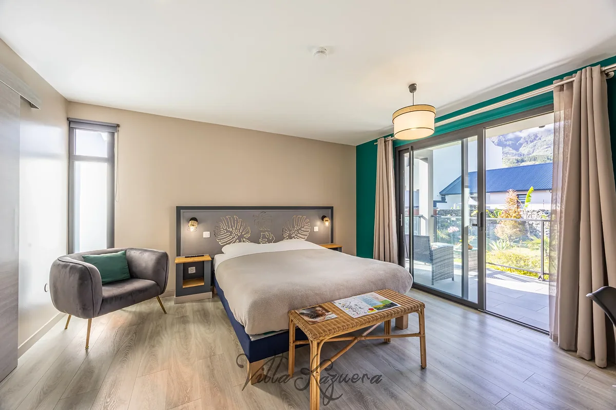Une chambre de la Villa Kazuera, son coin salon et sa baie ouverte sur la montagne